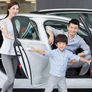 young-family-choosing-car-in-showroom-2023-11-27-05-06-41-utc